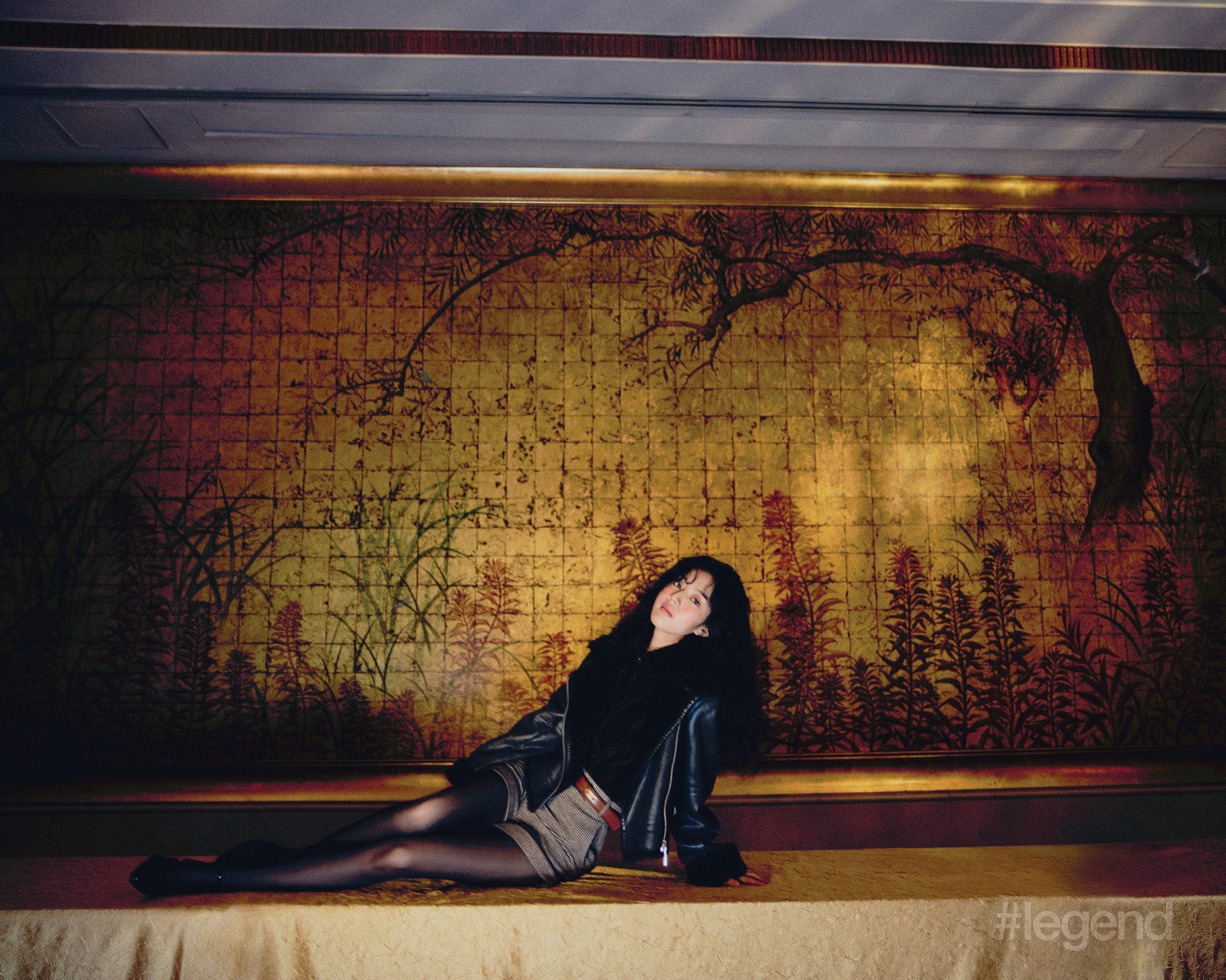 Black biker jacket and velvet shirt, beige shorts, brown belt, and black Mary Jane shoes _ MAX&Co. (Stylist’s own tights)